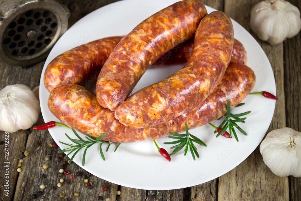 Raw sausages on white plate Raw sausages on white plate