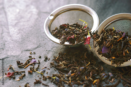 Foto Tea with flower petal in the strainer on the stone background horizontal