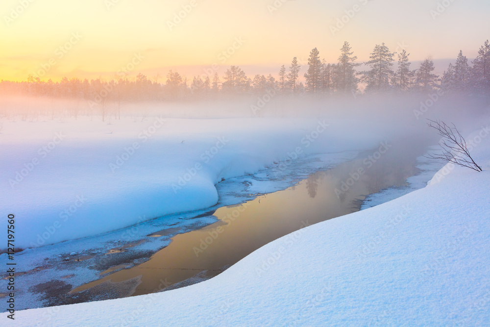 Colorful winter sunset in forest and river with beautiful misty