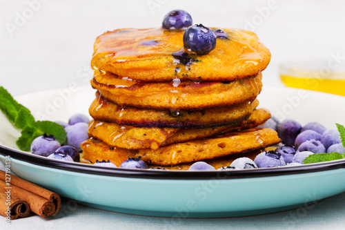 Pumpkin pancakes with blueberries, honey and cinnamon. Butternut squash cakes or fritters. Healthy breakfast, snack or take-away bites