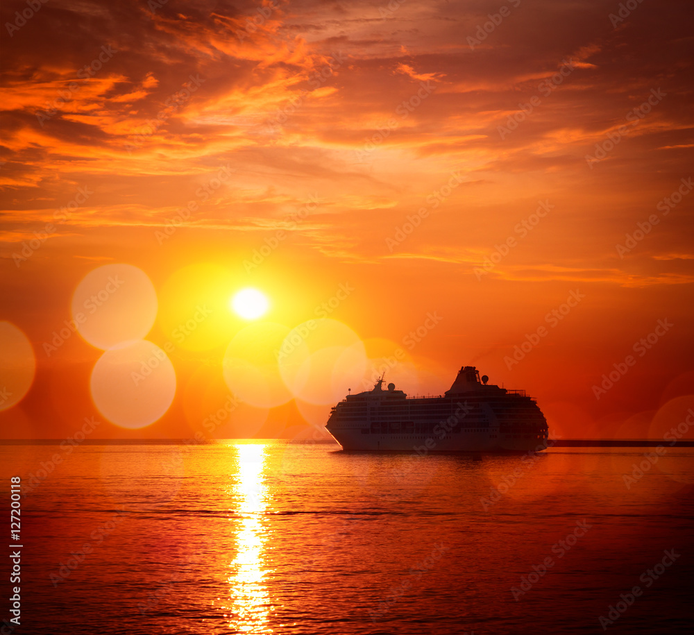 Silhouette of Cruise Ship at Sea. Beautiful Seascape Sunset Background. Romantic and Luxury Travel Concept. Toned and Filtered Photo with Bokeh. Copyspace.