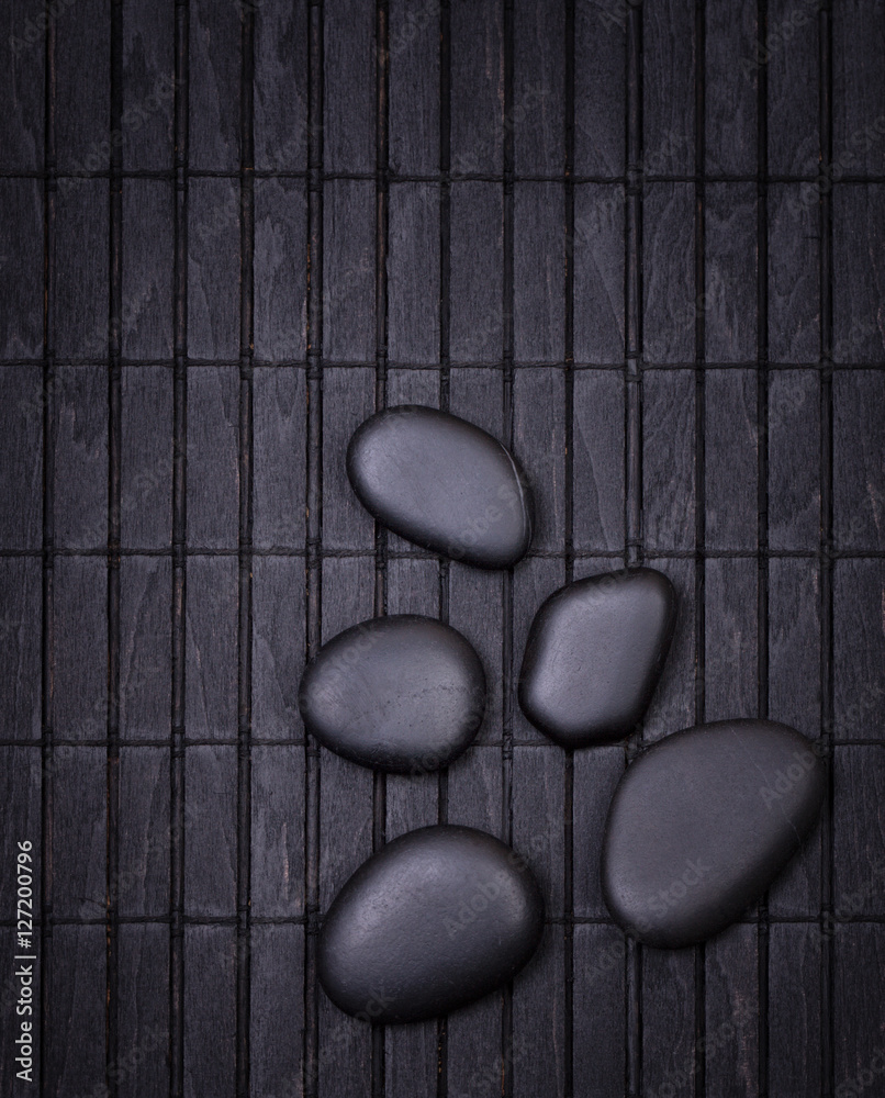 Black zen stones on a wooden black painted  dark surface