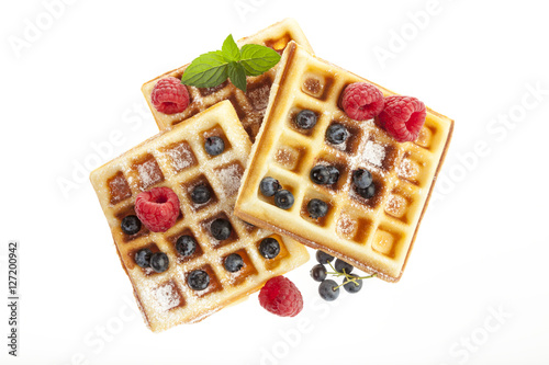Belgian waffles with raspberries and blueberries isolated on white