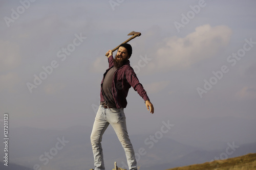 bearded man with ax on mountain