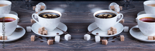 Tea, black tea, green tea, black espresso coffee in white porcelain cups on rustic wooden table. Wide panoramic image. 