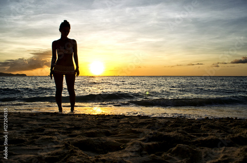 female Figure Watching the Sun Set on the Beach