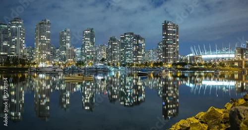 Vancouver, British Columbia, Canada - view over False Creek, Quayside Marina, Cambie Street Bridge and illuminated BC Place Stadium at night - Timelapse with pan left to right
