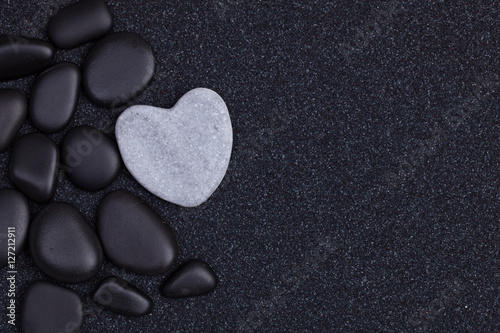 Canvas Print Black stones with grey zen heart shaped rock on  grain sand