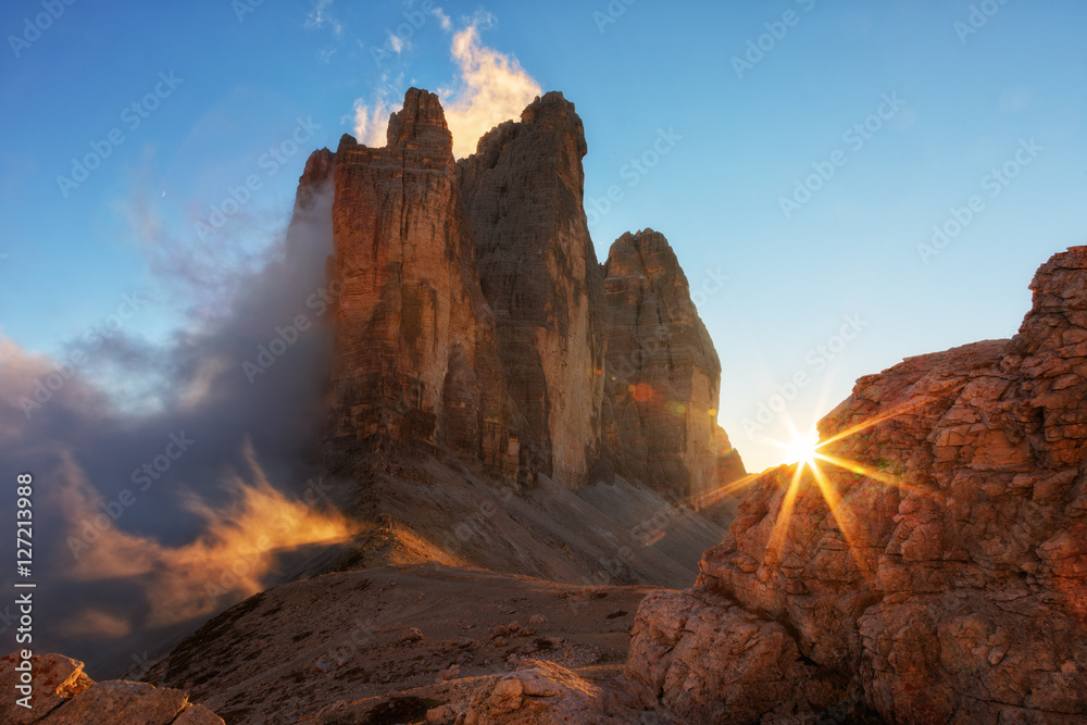 Fog, lit by the sun at sunset among the rocks the Cime di Lavaredo the Tre, Dolomites, Italy