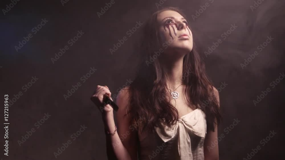 Scary vampire girl with a knife looking angry and have a sinister look. 4K UHD Scary vampire girl with a knife looking angry and have a sinister look. 4K UHD