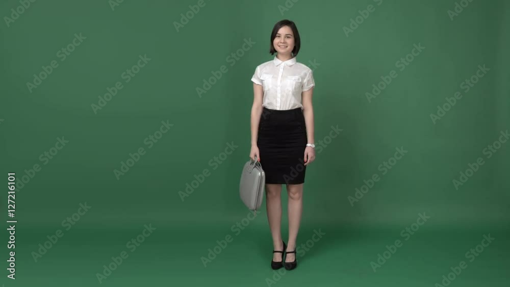 Nice brunette woman in business clothes with the suitcase coming, chroma key green screen background Nice brunette woman in business clothes with the suitcase coming, chroma key green screen background