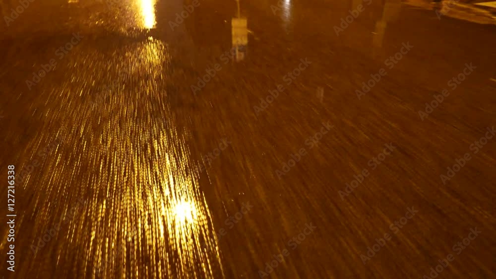 Walk through puddles on the pavement in the night. 4K UHD