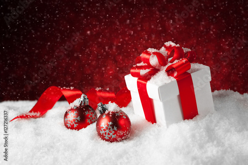 Christmas balls and gift box on snow.