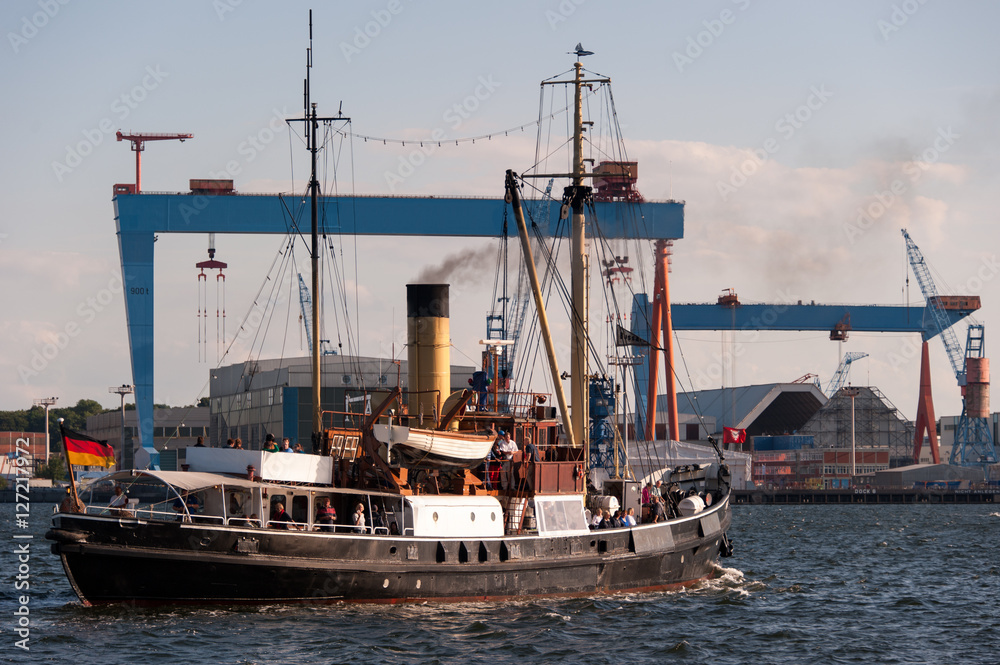 Bussard historischer Tonnenleger im Kieler Hafen vor einer Werftkulisse