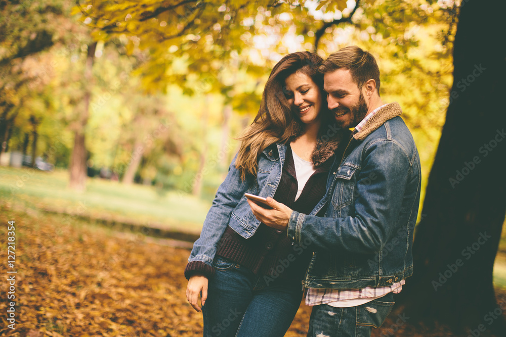 Couple with phone in autumn park Couple with phone in autumn park