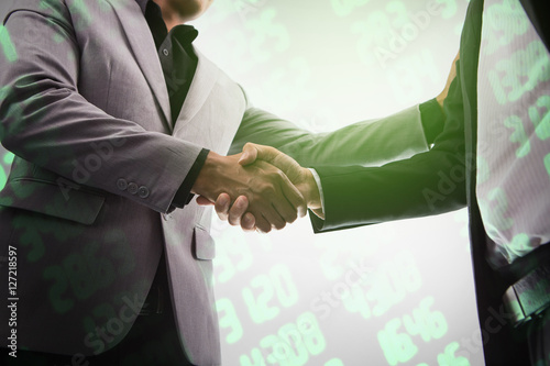 Business handshake on stock market background. Financial Agreement with Handshaking.