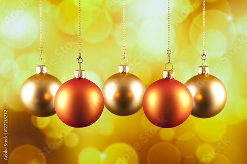 Four Christmas baubles on yellow background