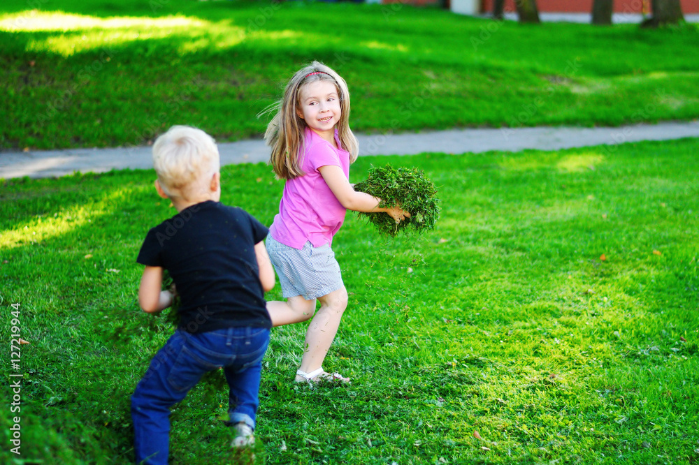 Obraz premium Adorable kids playing with cutted grass