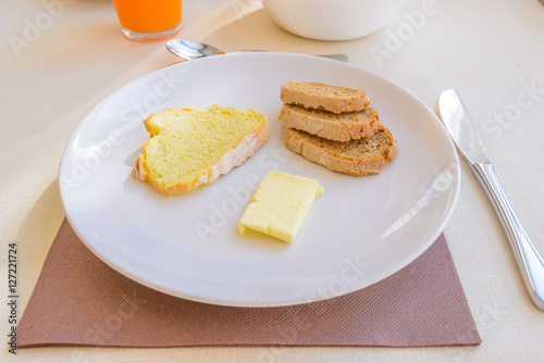 Breakfast including coffe  orange juce  bread  and butter.