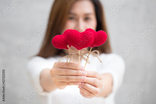 Giving love gift, Asian woman hand hold give beautiful red heart sweet loving symbol of take care or charity help to you.