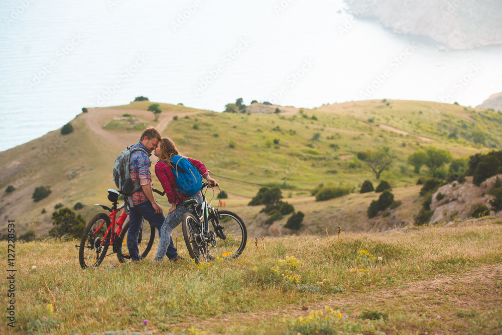 young couple riding bikes in the mountains young couple riding bikes in the mountains
