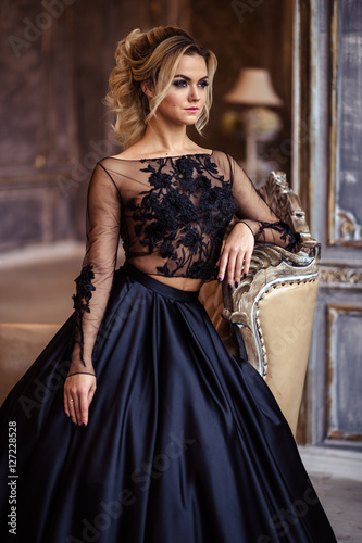 Slika na platnu Beautiful young woman in gorgeous black evening dress with perfect makeup and ha