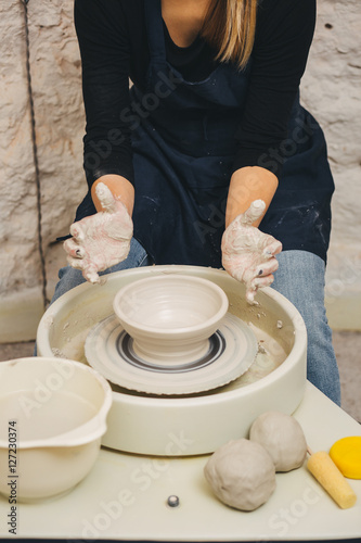 Female Potter creating bowl on Potters wheel