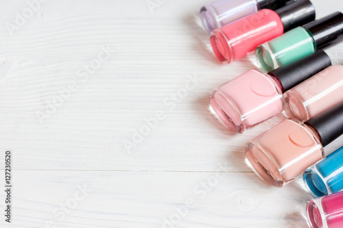 bottles of colored nail polish on wooden background