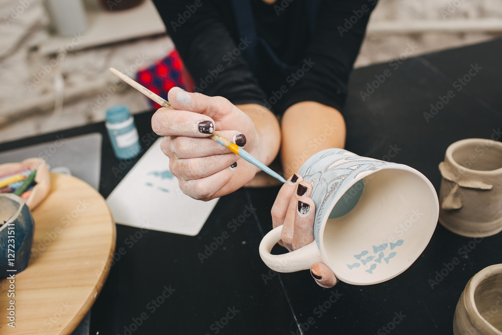 Female hands working on mug Female hands working on mug