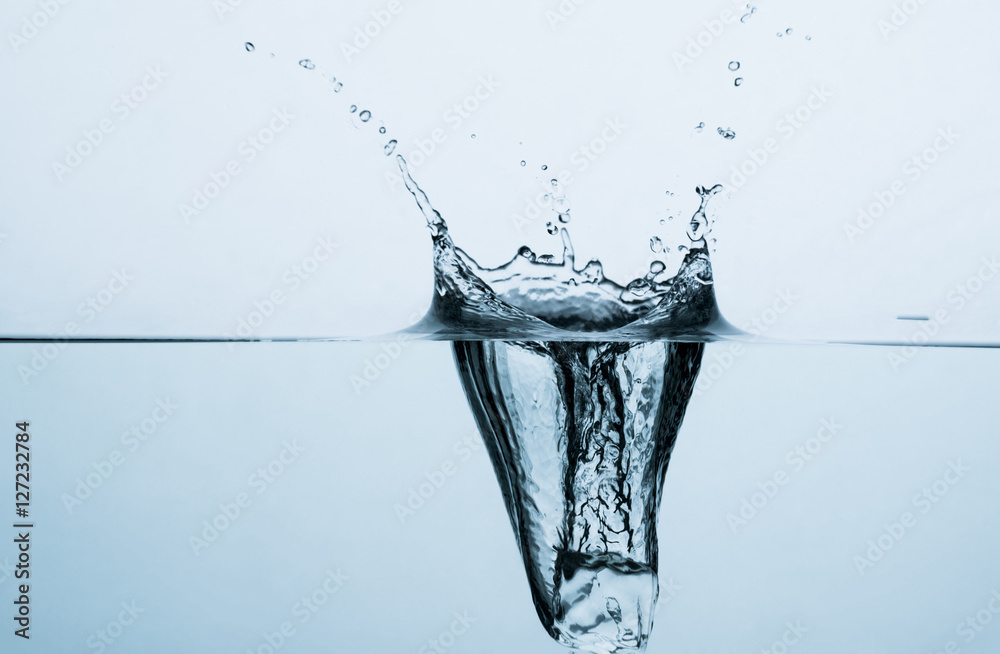 Fotografie Ice cube splashing in water
