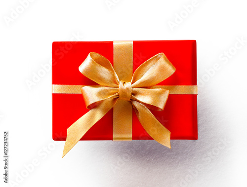 Red gift with golden bow on white background. Close up. Top view. High resolution product, top view