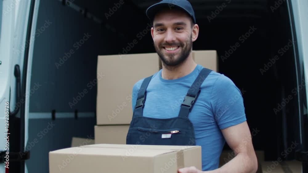 Smiling Delivery Man Holds Cardbord Box. Shot on RED Cinema Camera in 4K (UHD). Smiling Delivery Man Holds Cardbord Box. Shot on RED Cinema Camera in 4K (UHD).