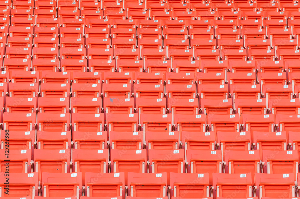 Empty orange seats at stadium,Rows of seat on a soccer stadium Empty orange seats at stadium,Rows of seat on a soccer stadium