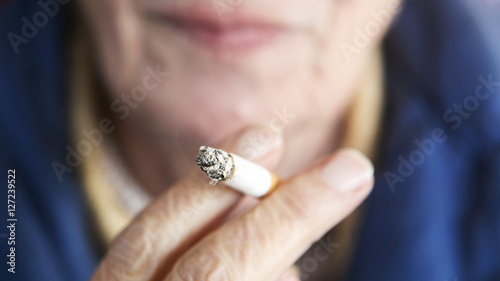 closeup of older woman holding a cigarette