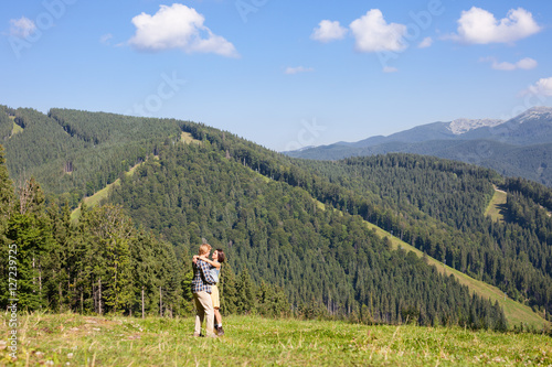 Happy beautiful couple on the green grass meadow