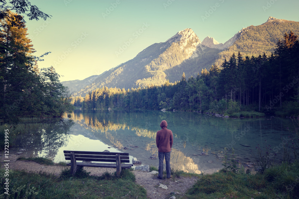 Man standing near the mountain lake Man standing near the mountain lake