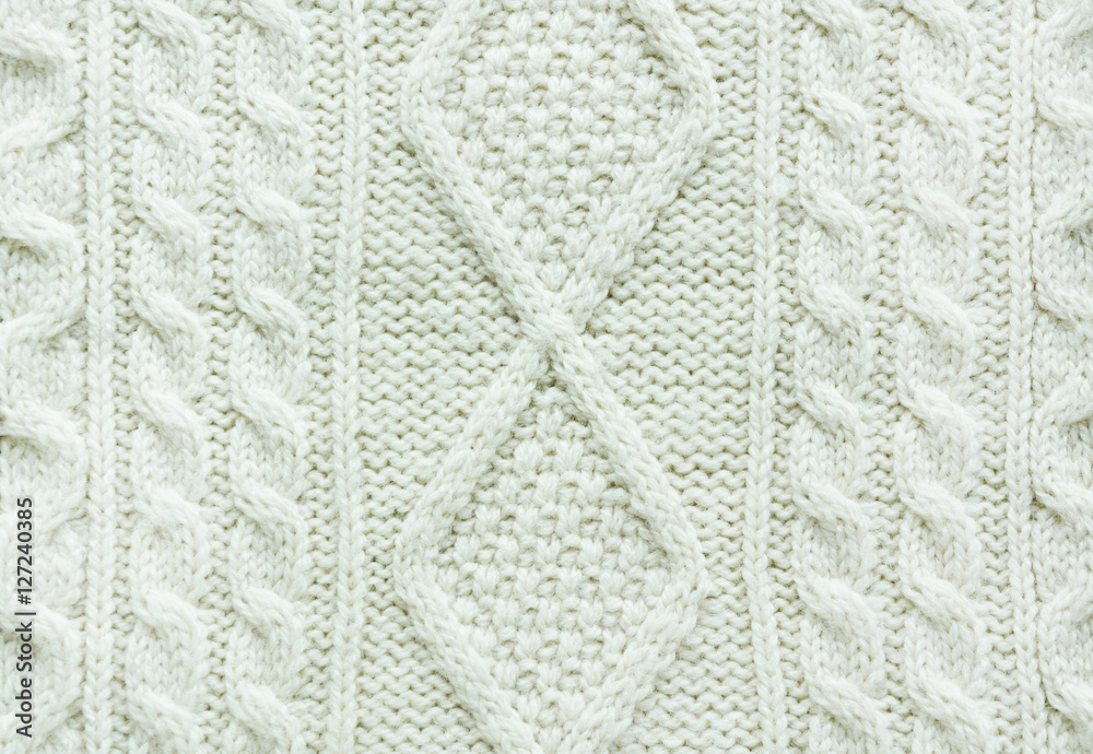 Texture of knitted handmade. Christmas white sweater close up. Wallpaper or abstract background.