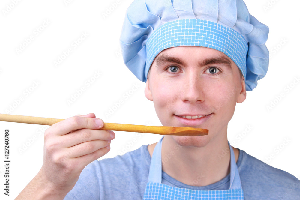 happy young chef tastes the dish with a wooden spoon happy young chef tastes the dish with a wooden spoon
