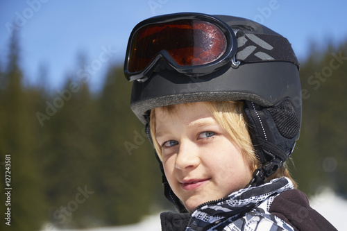 Portrait of little child boy in helmet and ski goggles on a sunny day in the mountains.     © Petr Bonek