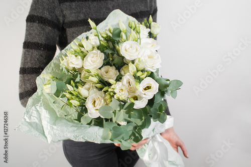 Fototapeta Naklejka Na Ścianę i Meble -  rich bouquet with eustoma lisianthus in woman hand . flowers and eucalyptus mint packaging