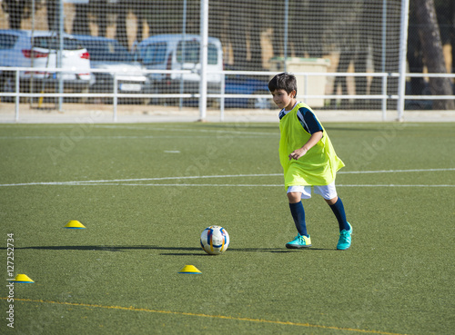 Niño en un entrenamiento de fútbol 7, deportes de equipo para actividades extraescolares