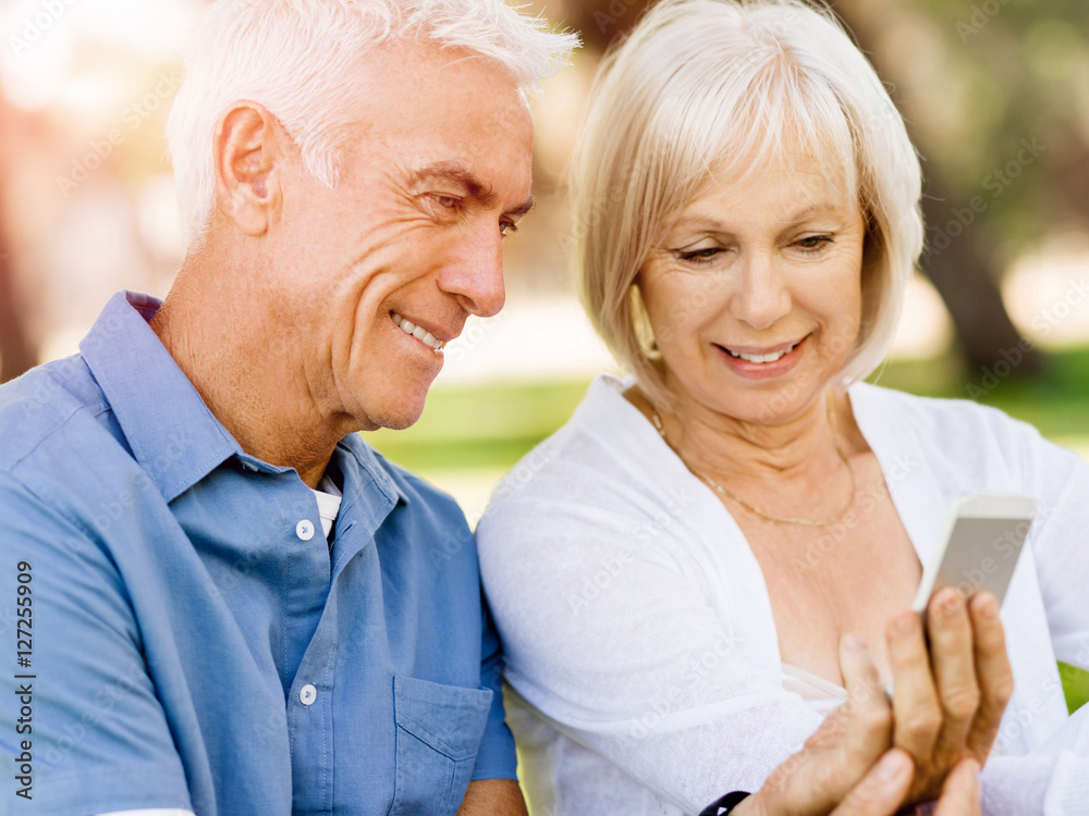 Happy senior couple looking at smartphone Happy senior couple looking at smartphone