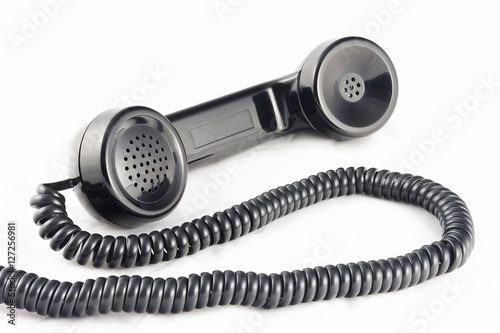 Outdated telephone handset with black with coil cable. Horizontal.