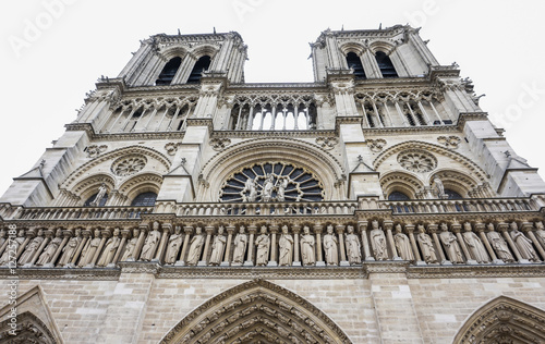 Frontage view low angle of western facade Notre-Dame de Paris in the white sky