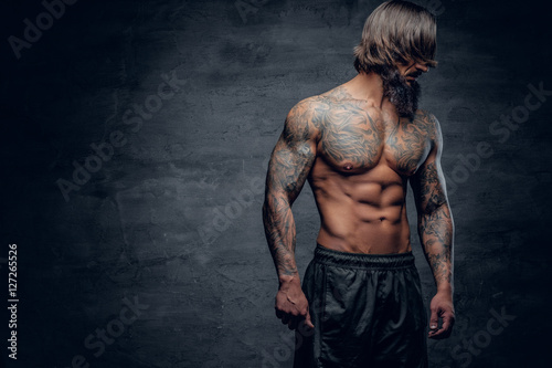Hipster male with tattooed muscular body.