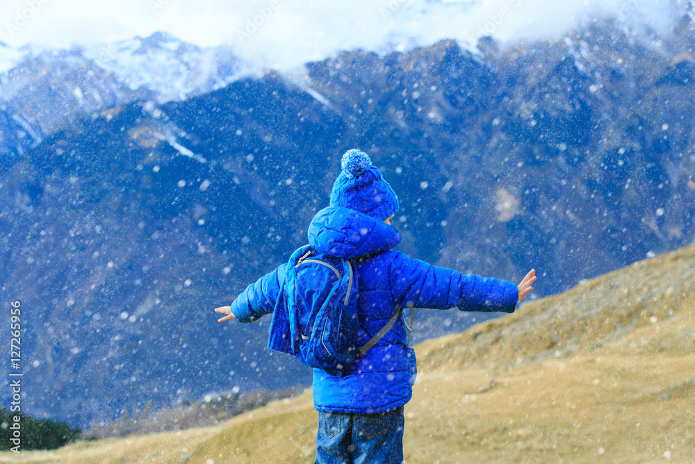little boy enjoy travel in winter mountains