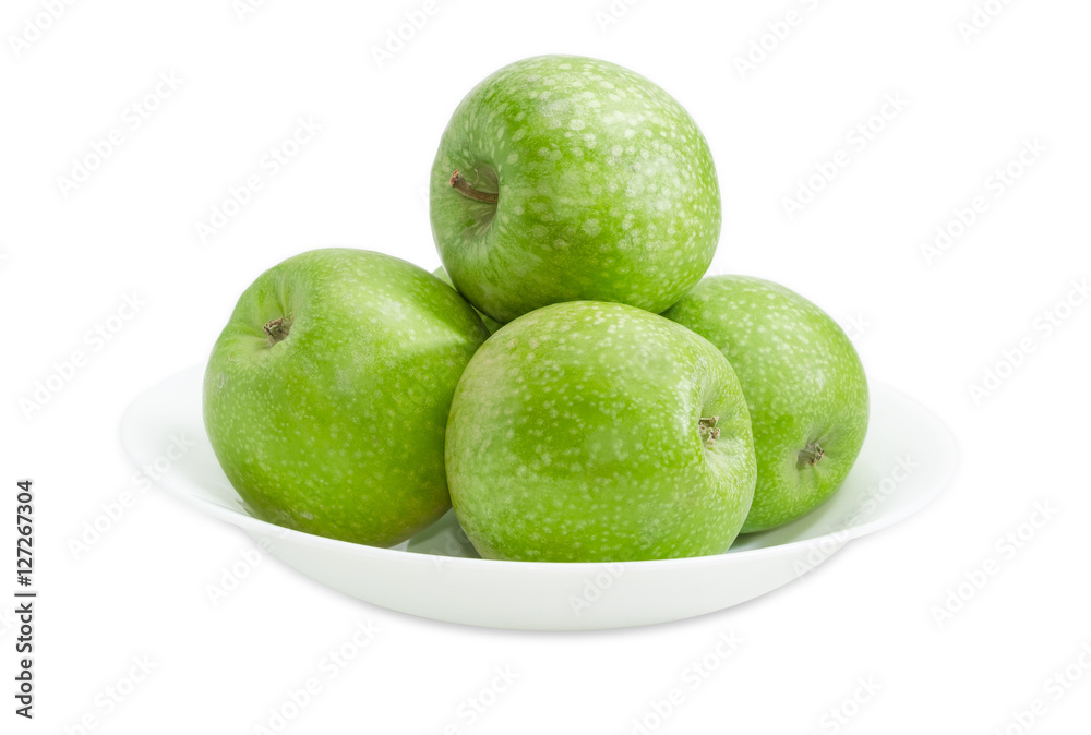 Several green apples on a white dish closeup Several green apples on a white dish closeup