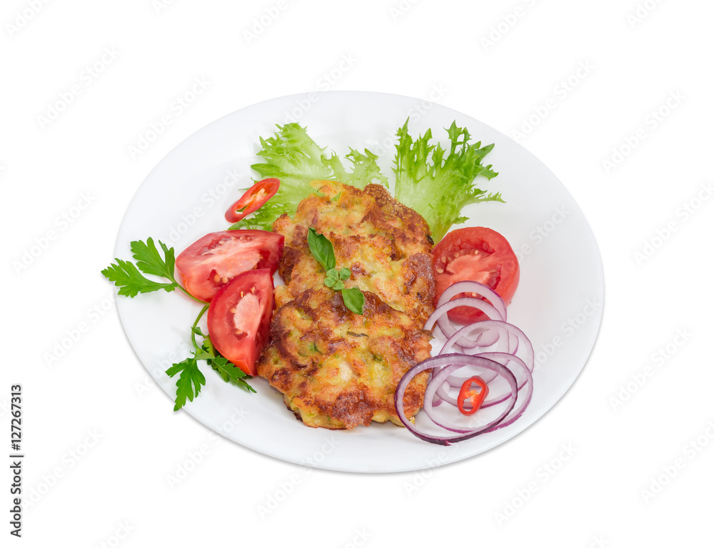 Chopped cutlets and vegetables on white dish on light background