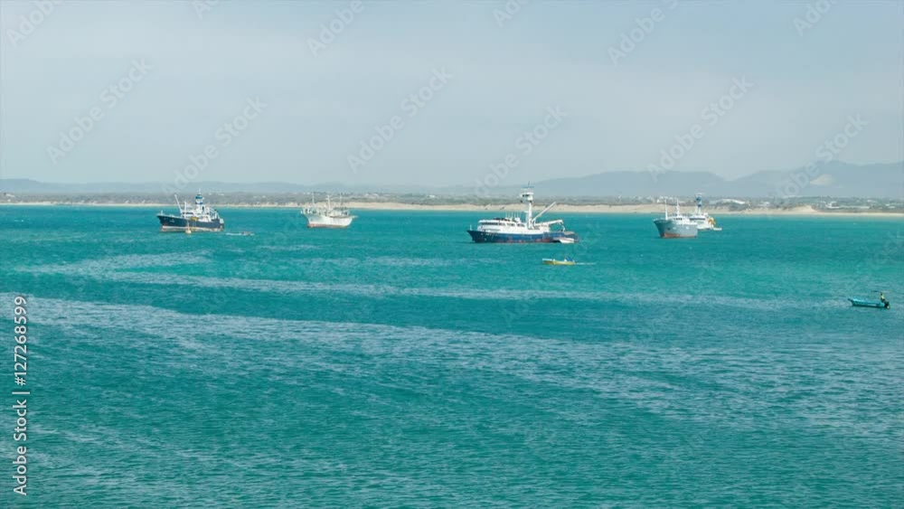 Fishing Boats in the Bay near Manta Ecuador with Turquoise Pacific Sea Water with Beach and Mountain Background