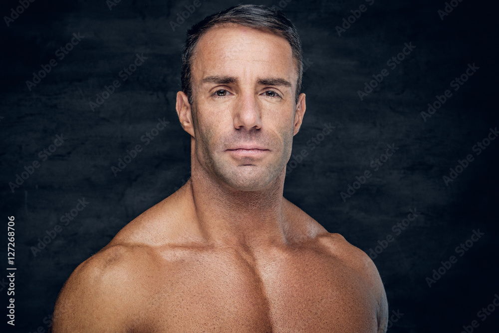 Portrait of muscular shirtless positive middle age male.